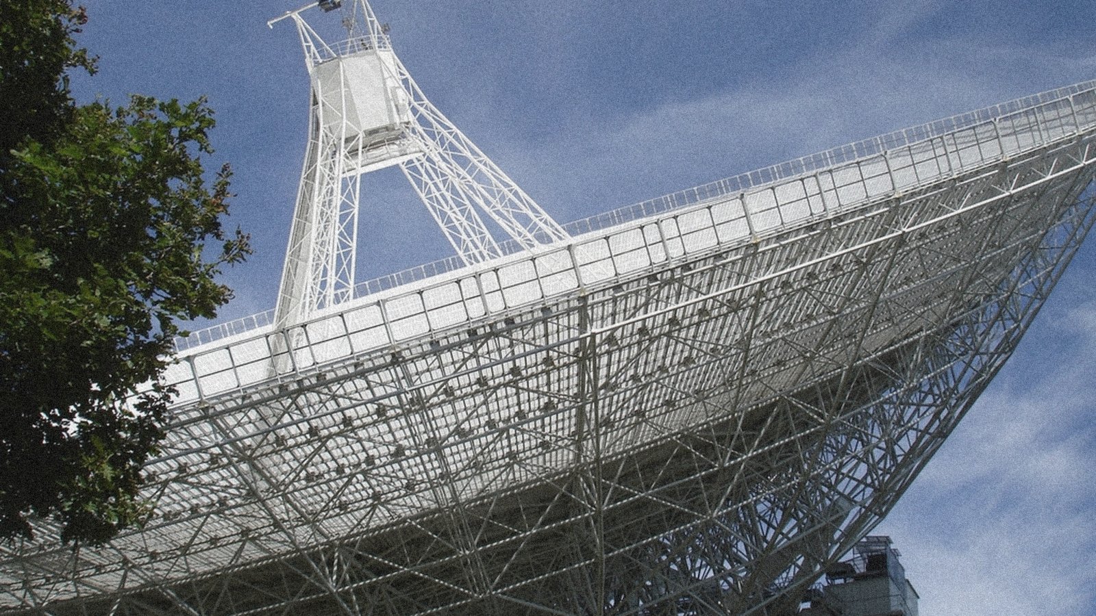 A radio telescope dish against a blue sky
