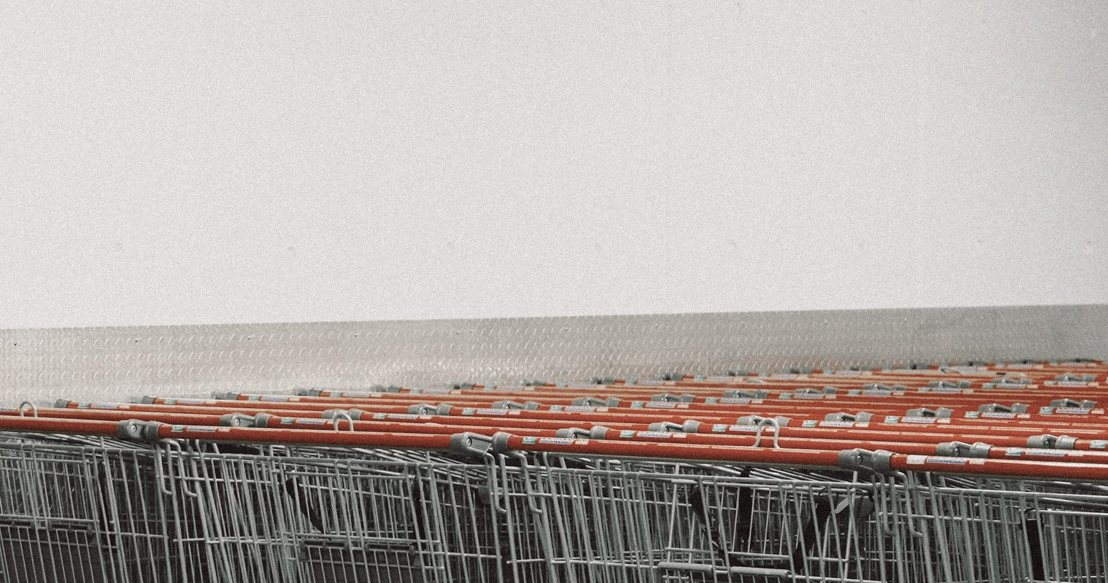 A row of shopping trolleys against a pale wall