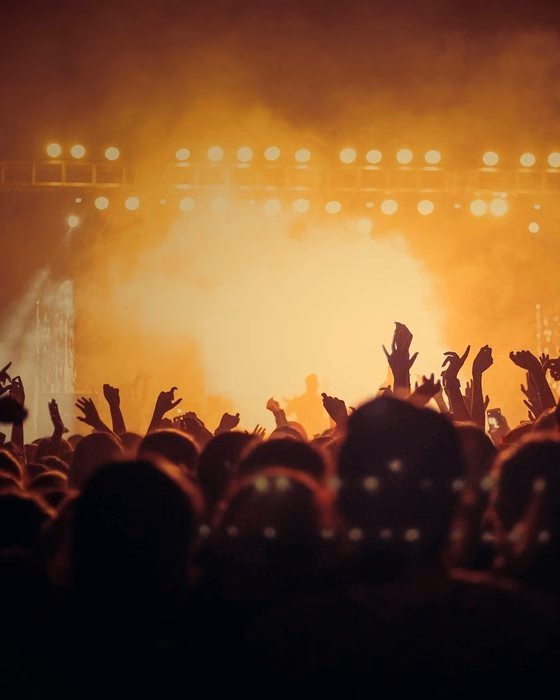 A stage lit in orange light above a crowd