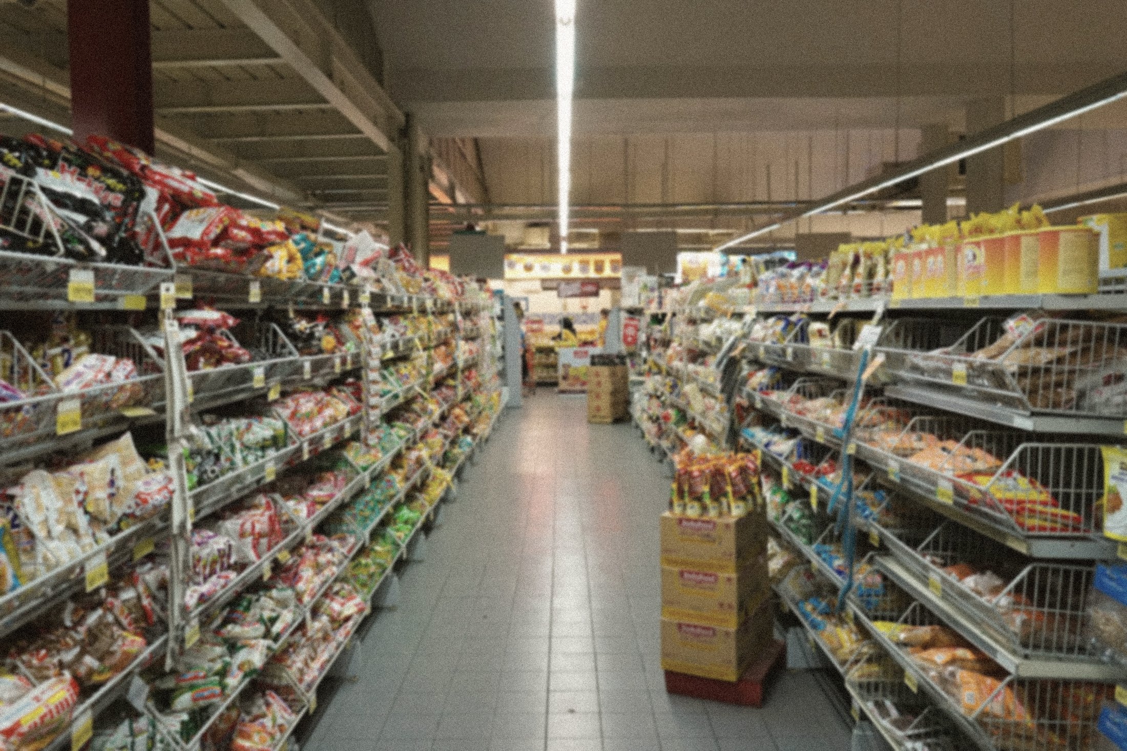 A supermarket aisle receding into the distance