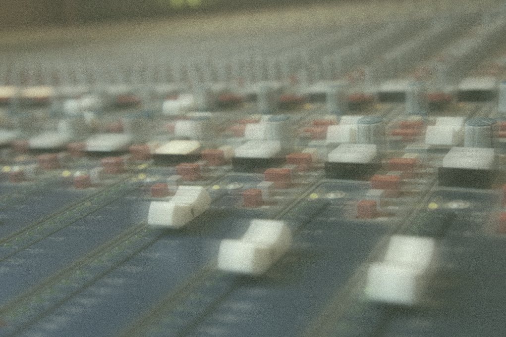 Faders on a mixing desk in soft focus